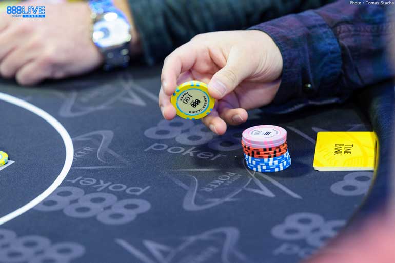 Mão segurando uma ficha de poker