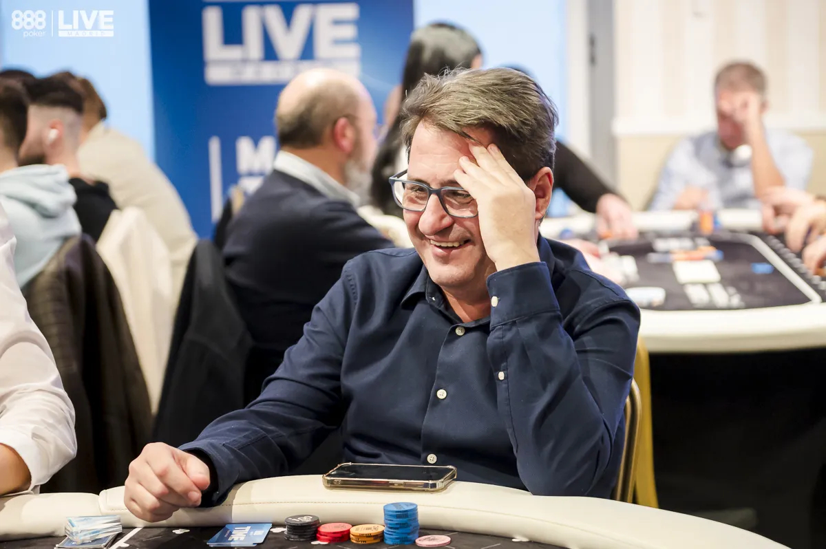 Homem jogando poker com óculos e rindo