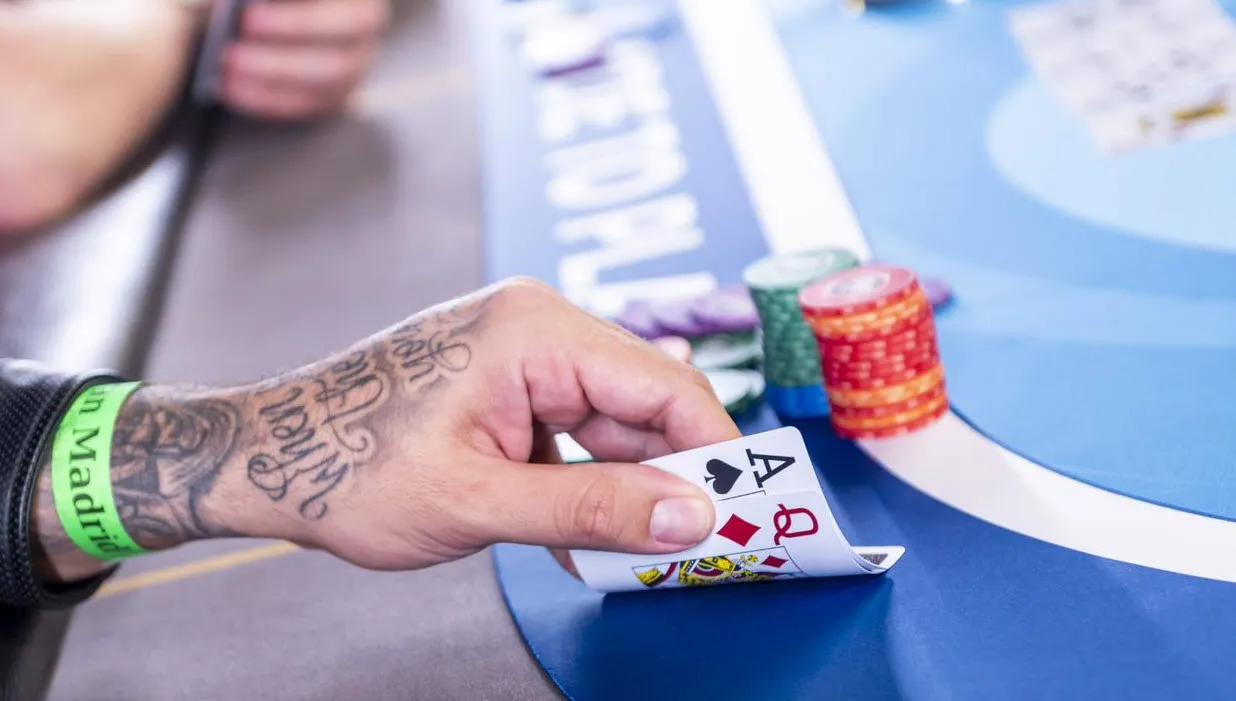 Homem olha suas cartas em jogo de poker