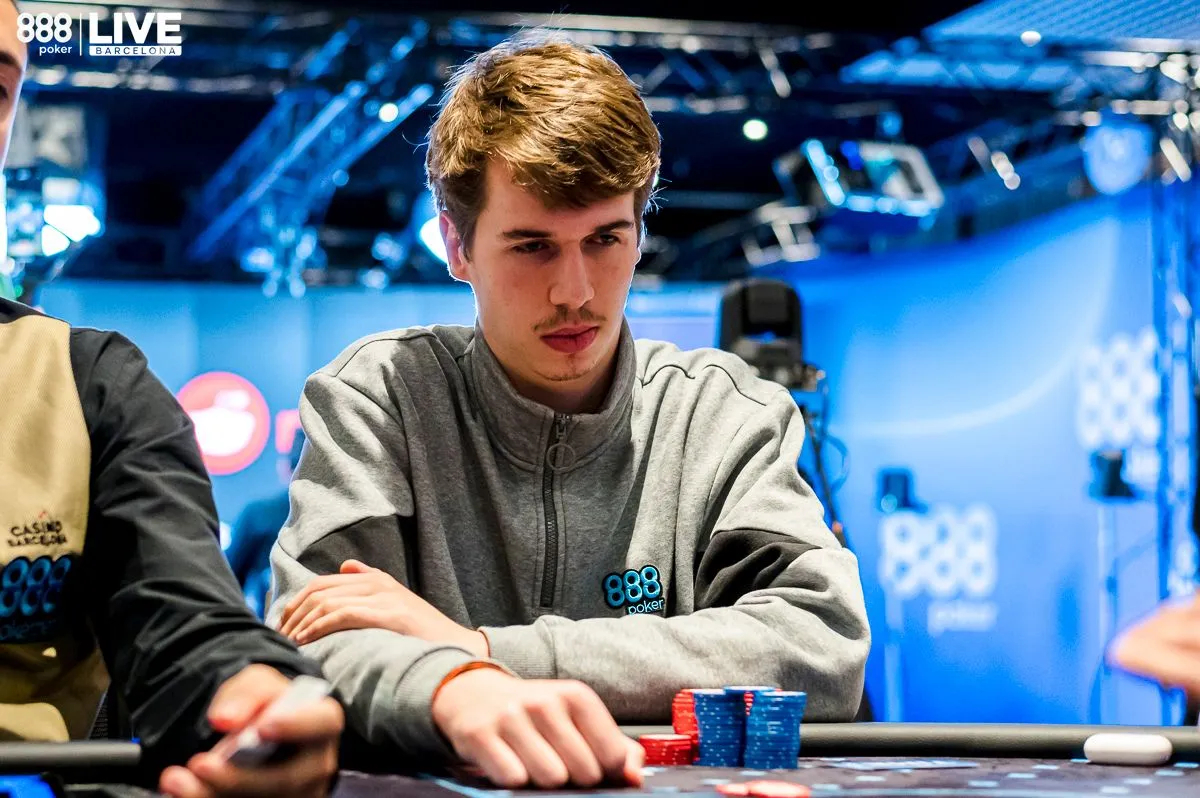 Homem com casaco da 888poker joga poker