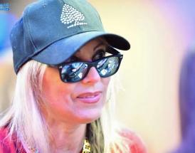 Mulher de óculos e boné jogando poker