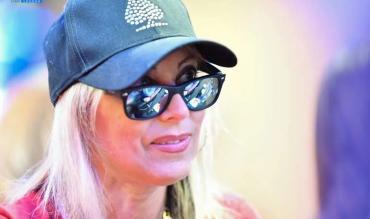 Mulher de óculos e boné jogando poker