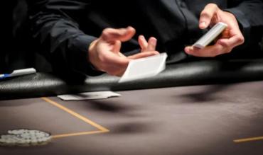Dealer dá carta em mesa de poker